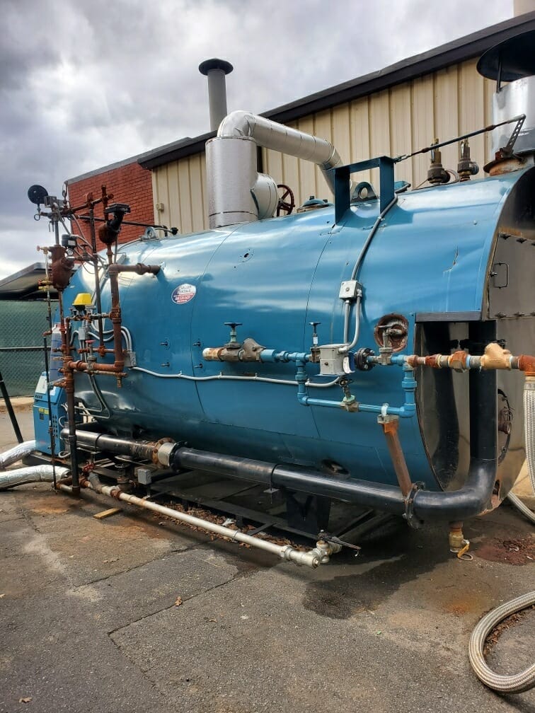Steam boiler set up outside a building, side view